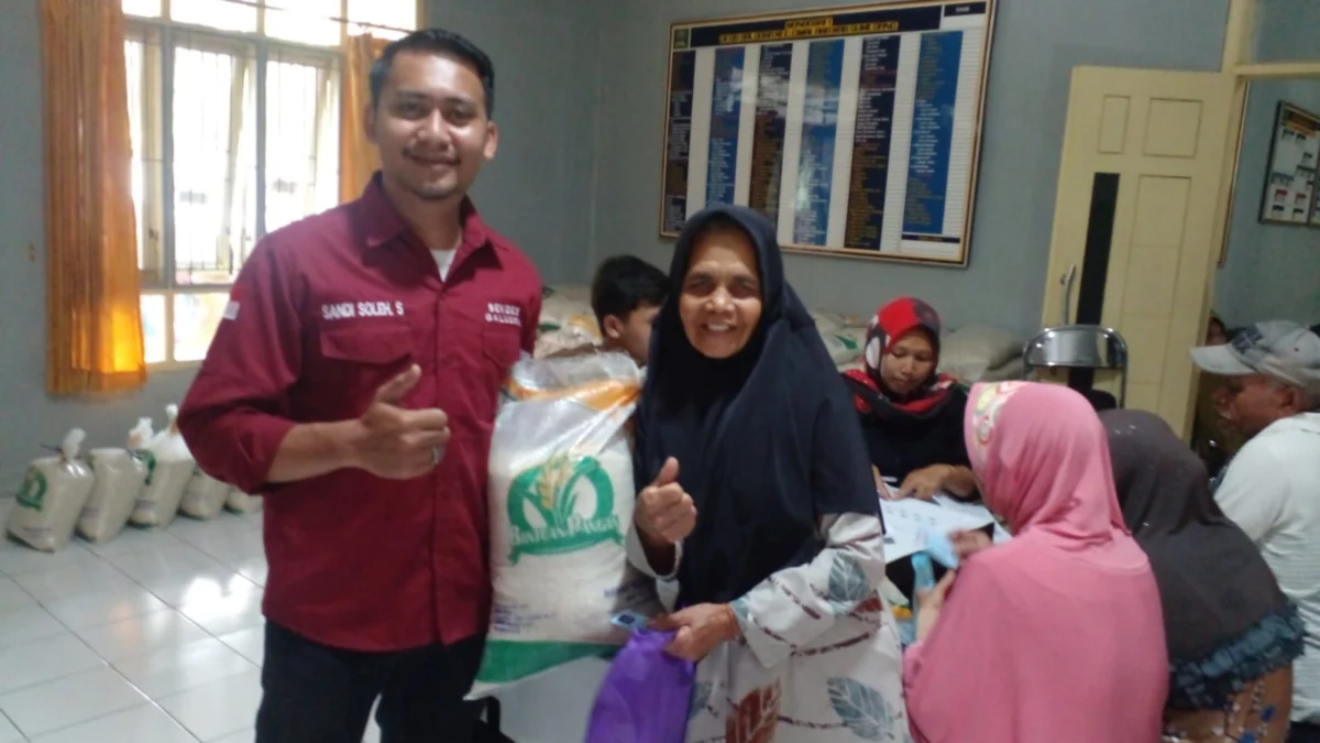 BAHAGIA: Sekretaris Desa, Galudra Sandi Soleh S Sos saat memberikan bantuan pangan kepada warganya ibu Cicih RT 01, RW 05, Dusun Gajahdepa, Desa Galudra, Kecamatan Cimalaka, Kabupaten Sumedang, kemarin.