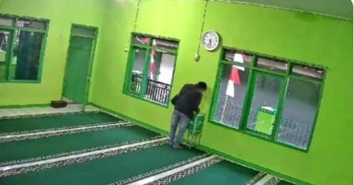 KRIMINAL: Aksi maling tersebut terekam kamera pengawas yang terpasang di masjid. Dia mengenakan jaket berwarna hitam, celana jeans dan bertopi yang menutupi sebagian wajahnya.(istimewa)
