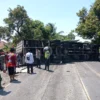 EVAKUASI: Anggota Satlantas Polres Sumedang dibantu warga melakukan evakuasi Truk Box yang terguling, di Tanjakan Nyalindung, Dusun Warung Buah, Desa Padanaan, Kecamatan Paseh, Rabu (13/9).(istimewa)