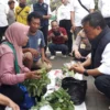 ATEP BIMO AS/SUMEKS BERBINCANG: Pj Bupati Sumedang Herman Suryatman saat berbincang dengan tukang sayur, dalam Kegiatan Pasar Murah di Alun-alun Tegalkalong, kemarin.