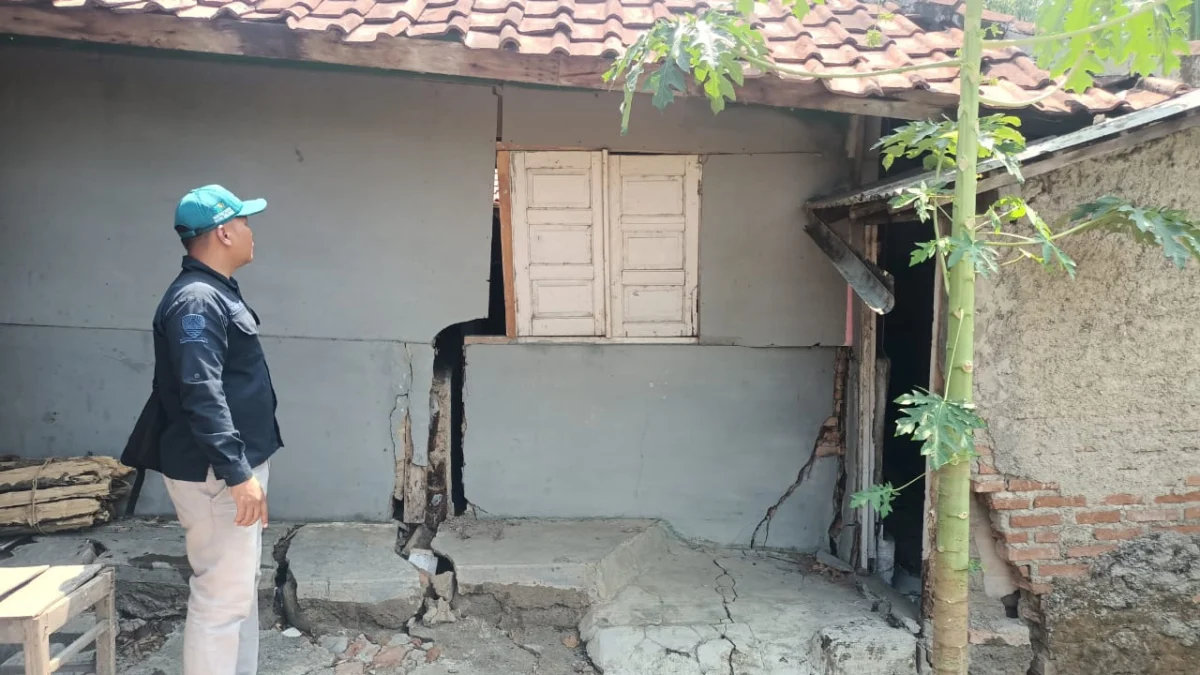 RETAK: Aparat Desa Cipelang menunjukkan bagian rumah warga yang rusak dan hampir roboh akibat adanya abrasi Sungai Cipelang, kemarin.