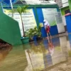 MENGGENANG: Para siswa dan guru terpaksa membuka alas kaki saat akan masuk sekolah karena pintu gerbangnya terendam air, di halaman Gedung Sekolah Dasar Negri (SDN) Parakanmuncang 2, Desa Sindangpakuon, Kecamatan Cimanggung, kemarin