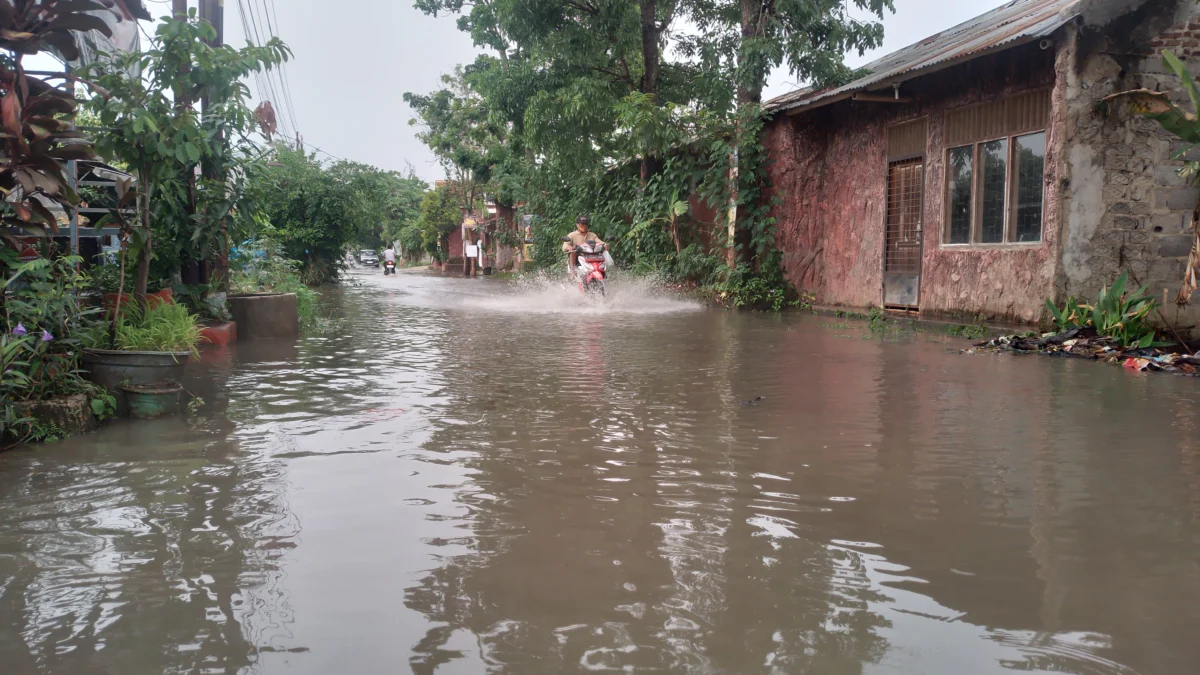 BAHAYA: Salah seorang pemotor nekat menerobos genangan banjir di salah satu ruas jalan di Kabupaten Sumedang. BMKG meminta warga untuk tetap waspada dan mengikuti informasi terkini.