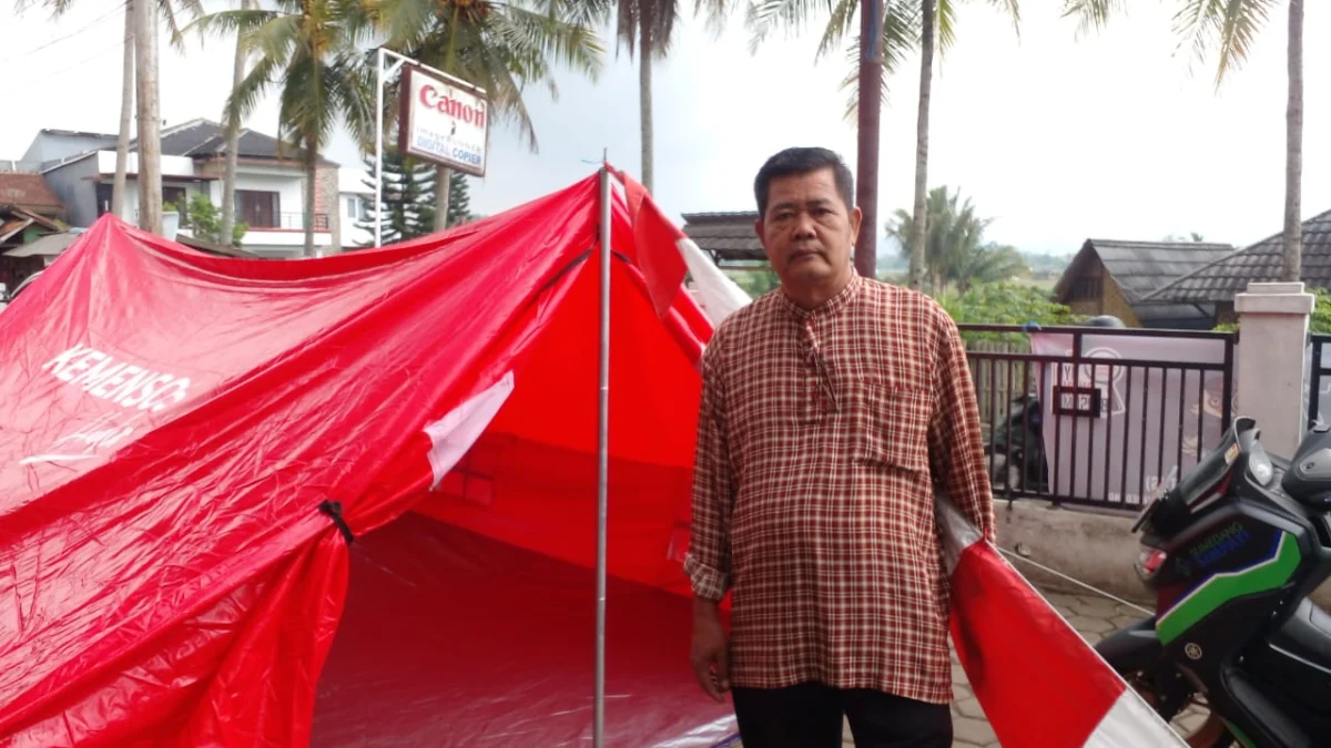 PANTAU: Kepala Desa Padasuka, Gamis saat menunjukan tenda darurat di depan kantor desa pada pemberlakuan siaga tanggap bencana, kemarin.