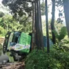 TERBALIK: Bangkai truk tronton yang terguling masih belum dievakuasi petugas pasca mengalami insiden terguling di Dusun Cilengsar RT 03 RW 02 Desa Ciherang, Kecamatan Sumedang Selatan, baru-baru ini.