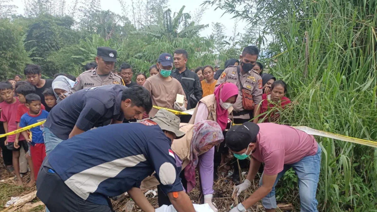 Polisi, Kepala Desa Sindangpakuon dan warga saat berada di pemakaman umum untuk menguburkan jasad bayi, baru-b