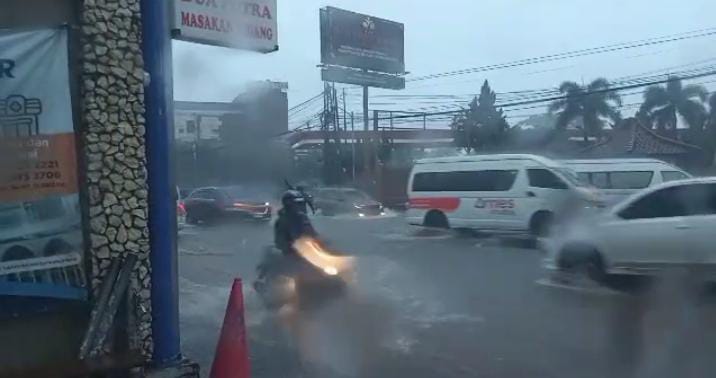 TERENDAM: Pemotor saat melintasi Jalan Raya Jatinangor Desa Cibeusi, Kecamatan Jatinangor yang tergenang air saat hujan, membuat para pengendara harus berhati hati saat melintas, baru-baru ini.