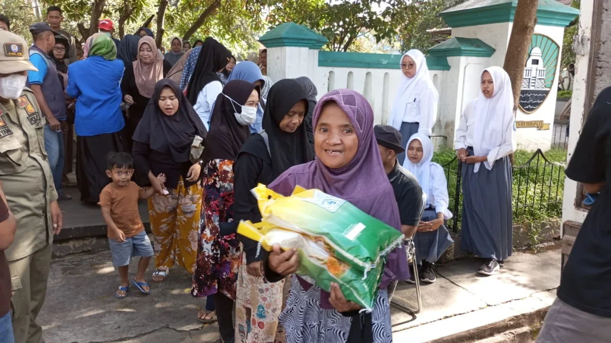 SUMRINGAH: Salah seorang warga Sumedang Utara berhasil mendapatkan jatah beras murah, pada operasi pasar yang