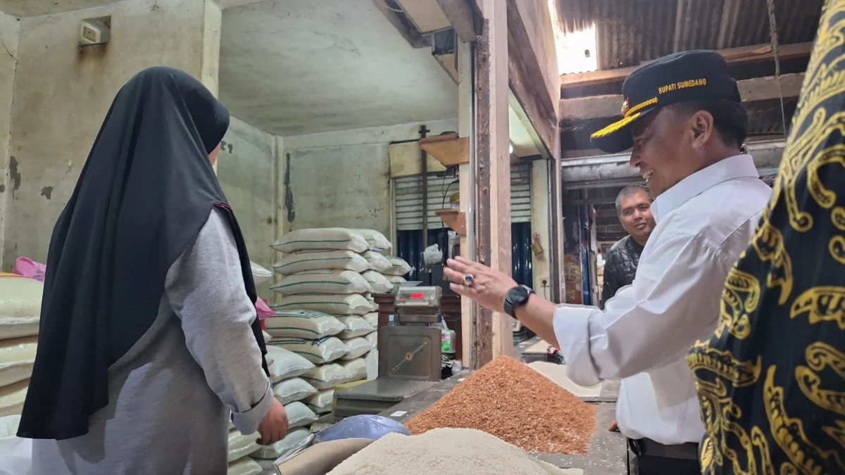 PANTAU: Pj Bupati Sumedang, Herman Suryatman saat mengecek harga beras di pasar tradisional Sumedang, yang tid