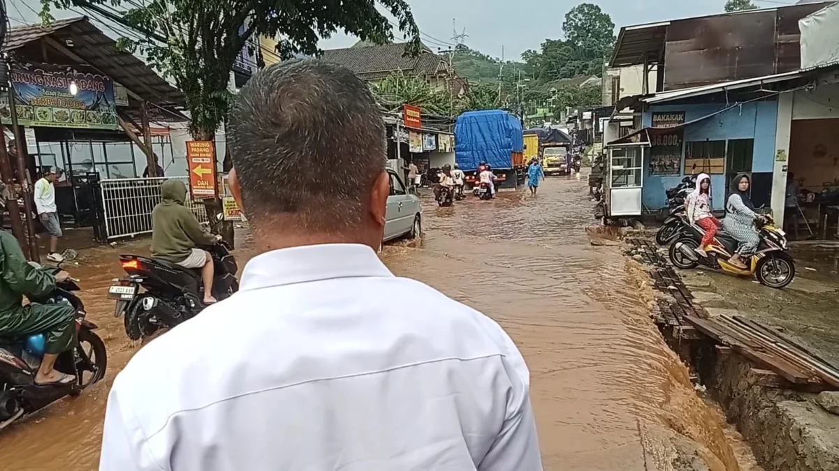 TERGENANG: Camat Cimanggung H Agus Wahyudin saat memantau langsung jalan provinsi di Jalan Raya Parakanmuncang