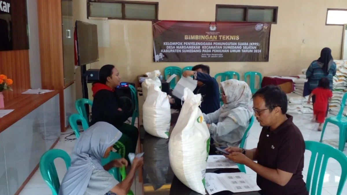 TERTIB: Para staf Desa Margamekar saat membagikan beras 10 kg kepada keluarga penerima manfaat (KPM) Desa Marg