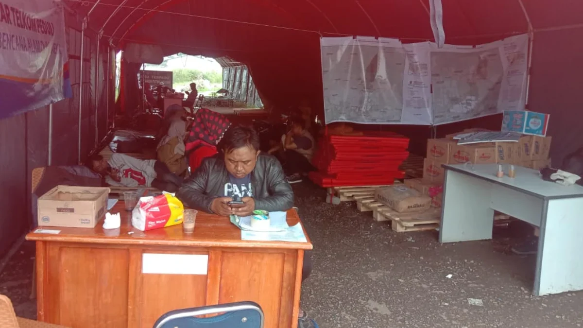MENGUNGSI: Petugas BPBD saat berjaga di tenda darurat, untuk memantau korban yang belum bisa kembali ke rumah