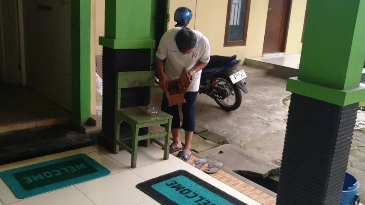 PERLIHATKAN: Seorang pengurus Masjid Al Muthmainnah Kecamatan Paseh memperlihatkan kotak amal yang hilang, bar