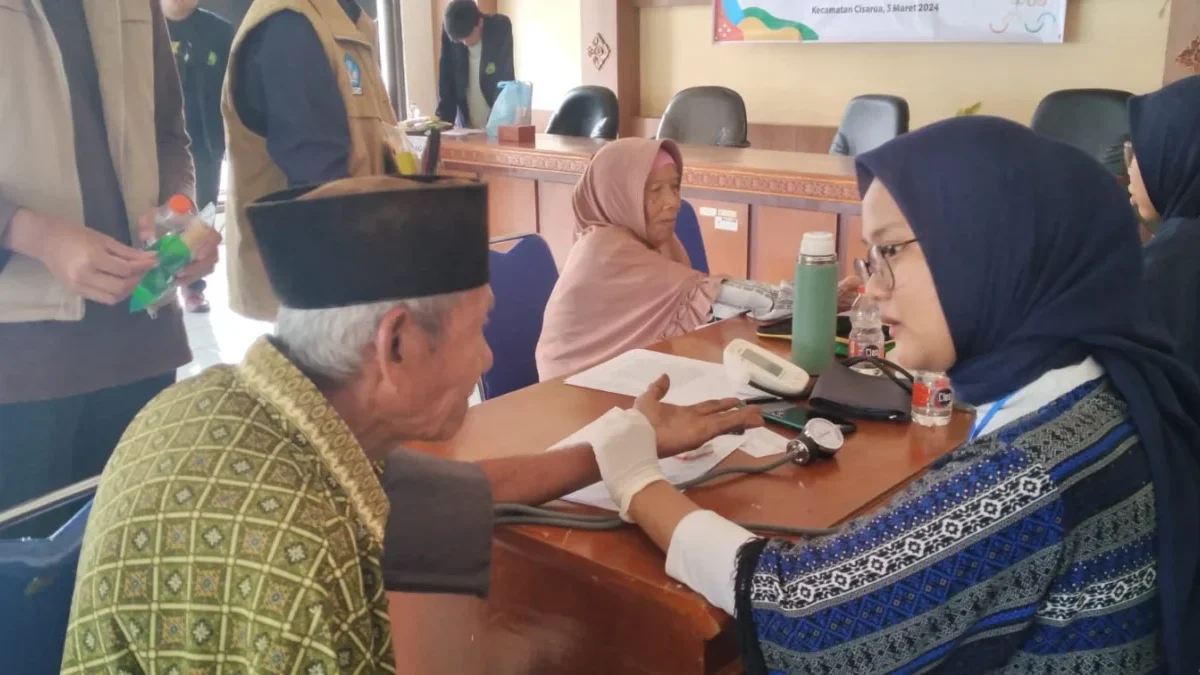 TERTIB: Salah satu lansia saat ditangani oleh petugas medis untuk mengecek kesehatan di Aula Kecamatan Cisarua