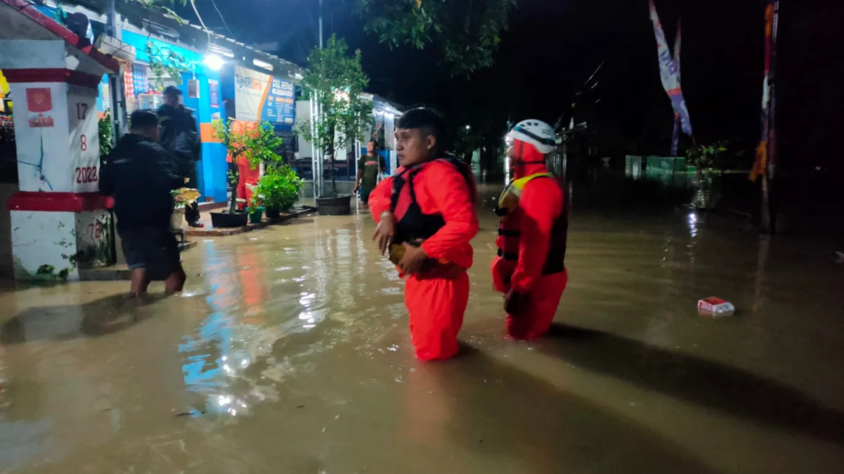 TERJUN LANGSUNG: Petugas BPBD Kabupaten Sumedang dibantu aparat setempat menangani banjir di Kecamatan Tomo, b
