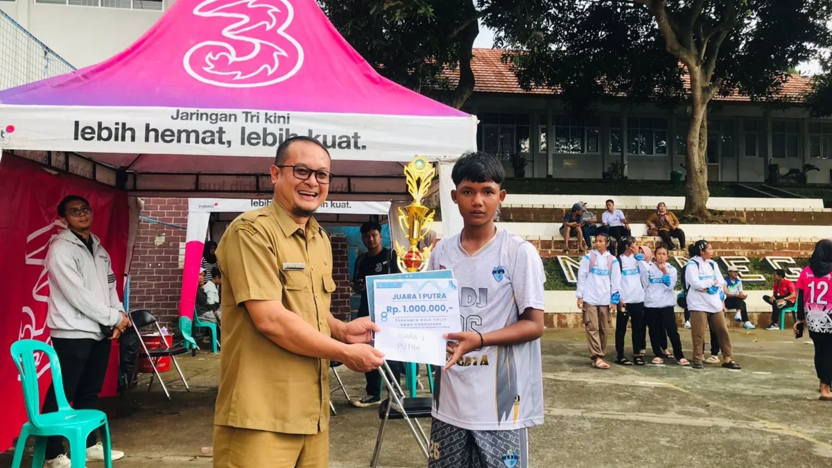SERAHKAN: Kepala SMAN 1 Conggeang Anggi Indra G saat menyerahkan tropi kepada juara turnamen bolavoli, baru-ba