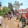 BEJIBAKU: Anggota TNI bersama warga masyarakat melaksanakan kerja bakti membersihkan lumpur di Desa Marongge,