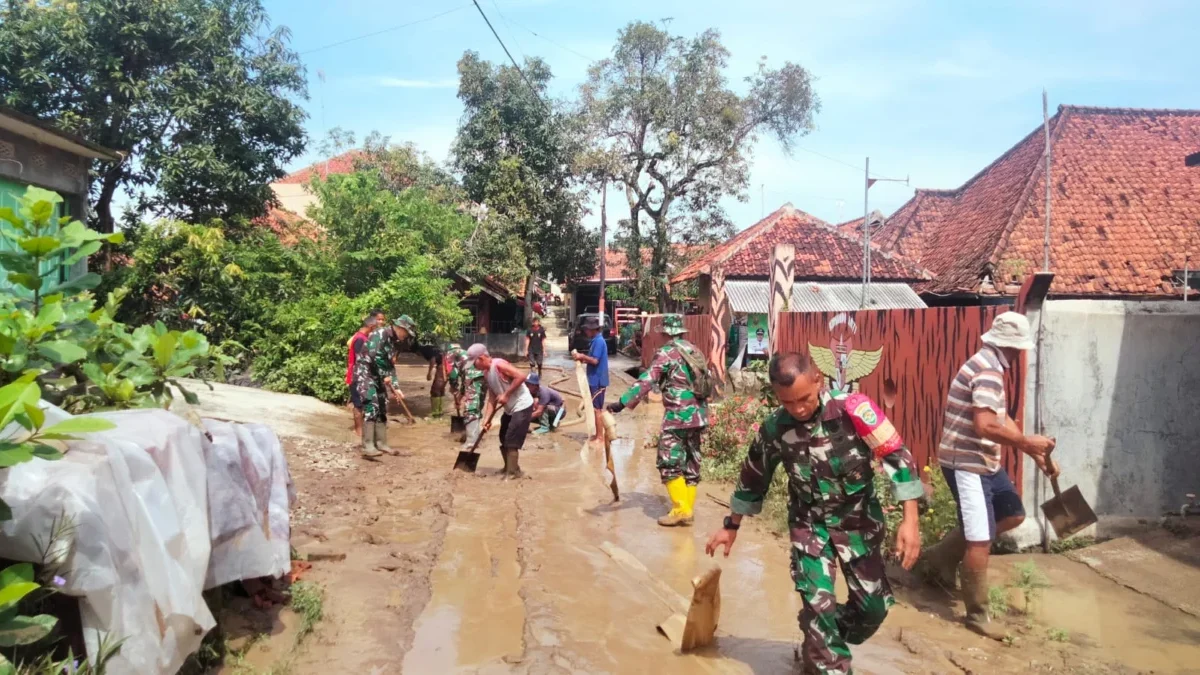 BEJIBAKU: Anggota TNI bersama warga masyarakat melaksanakan kerja bakti membersihkan lumpur di Desa Marongge,