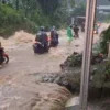 WASPADA: Beberapa warga saat melintas di Jalan Lingkar mesti waspada akibat meluapnya Sungai Cibogo yang memen