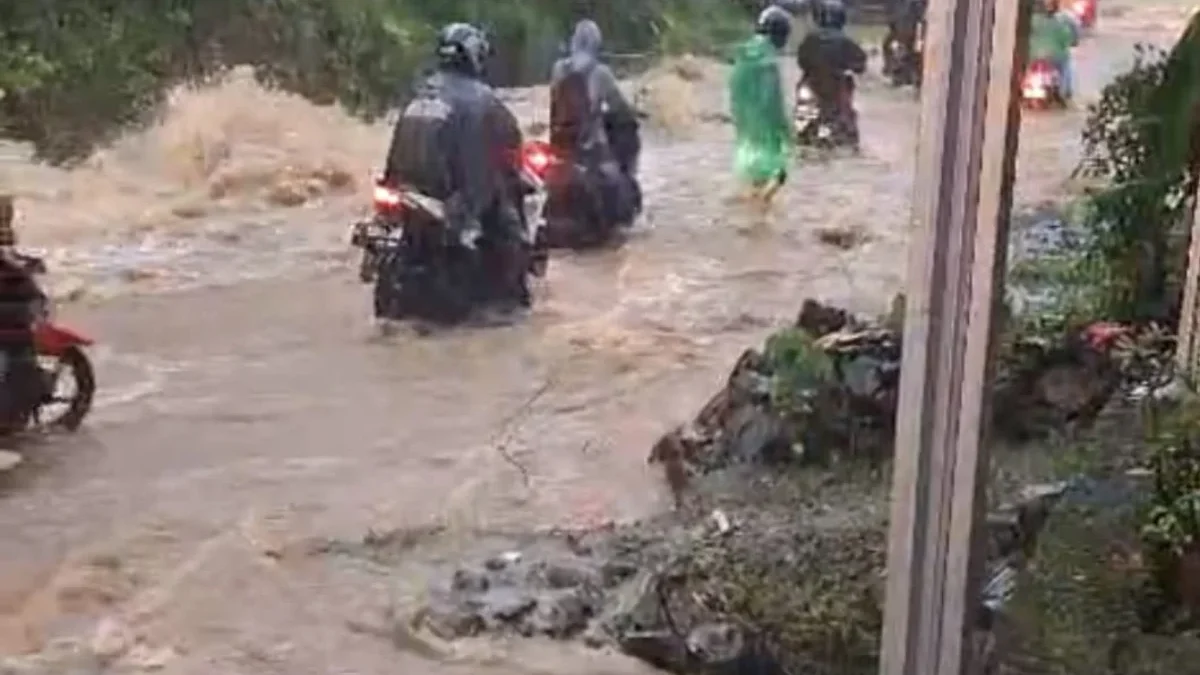 WASPADA: Beberapa warga saat melintas di Jalan Lingkar mesti waspada akibat meluapnya Sungai Cibogo yang memen
