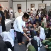 ANTUSIAS: Komisaris PT Persib Bandung, Umuh Muchtar saat membagikan santunan kepada anak yatim dan lansia, bar