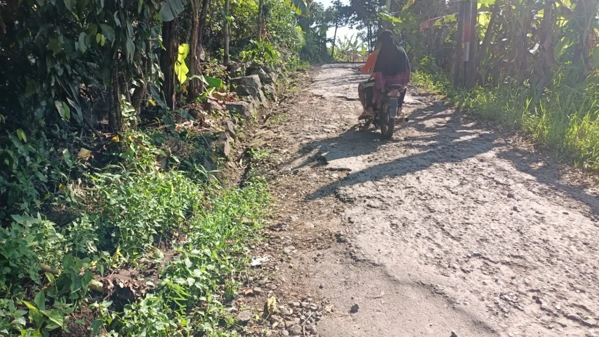 MEMPRIHATINKAN: Seorang pengendara motor harus waspada saat melintas di jalan kabupaten ruas Legok-Sukatali ka