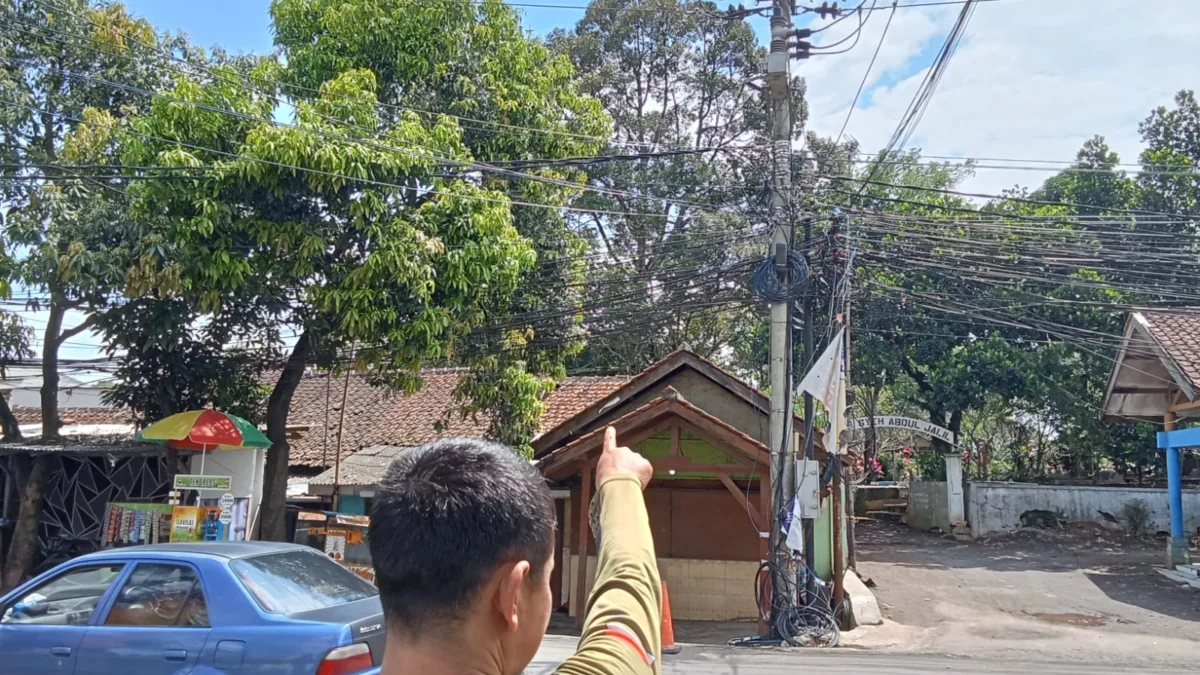 WASWAS: Petugas piket kantor kecamatan, Bule saat menunjukkan percikan api dari tiang listrik milik PT PLN Per