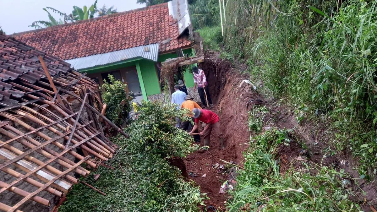 GOTONG ROYONG: Sejumlah warga melakukan kerja bakti untuk membersihkan tanah yang longsor, di Pamulihan (25/5.