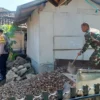 BERSINERGI: Anggota Babinsa Serka Zaenal Asikin saat membantu warga membangun Posyandu di Desa CIbeureum Weta,