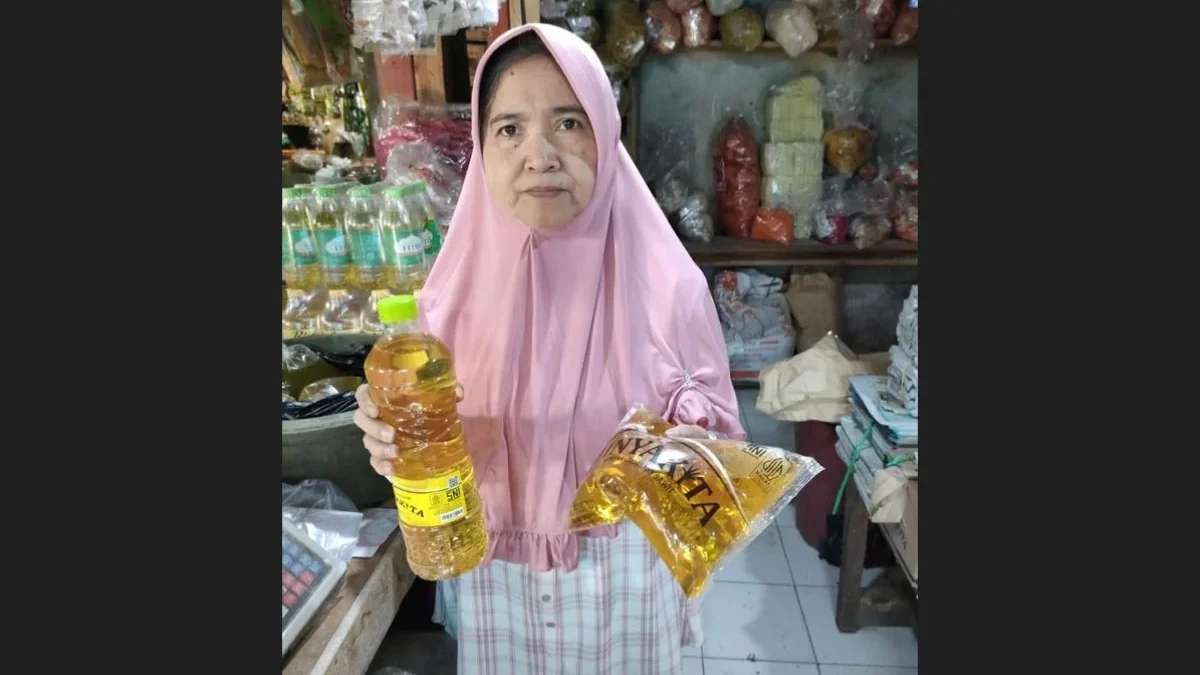 TUNJUKAN: Seorang pedagang pasar Tradisional Tanjungsari memperlihatkan stok Minyakita dengan harga jual dilua