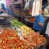 PANTAU: Petugas pasar Parakanmuncang saat memantau harga kebutuhan pokok di salah satu pedagang sayuran, Selas