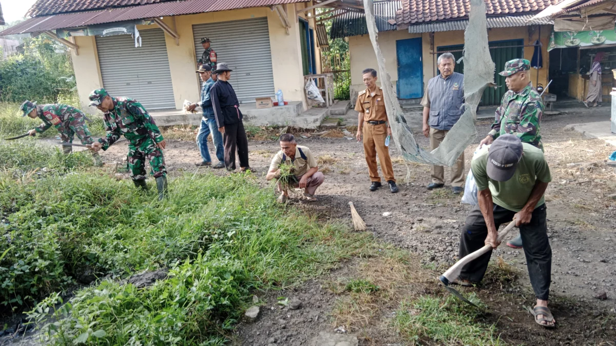 BERSINERGI: Danramil 1002/Cimalaka Kapten Inf Lesly Darmawan beserta anggota melaksanakan kegiatan Karya Bhakt