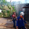 PADAMKAN: Petugas Pemadam Kebakaran UPT Damkar wilayah Tanjungsari pada saat memadamkan api di sebuah bengkel