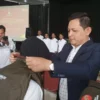 KHIDMAT: Ketua KPU Sumedang Ogi Ahmad Fauzi menyematkan kelengkapan kerja anggota Pantarlih secara simbolis, u