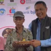 BERIKAN: Kepala Dinas Sosial Kabupaten Sumedang, Dikdik Sadikin, saat memberikan tumpeng ke salah satu lansia