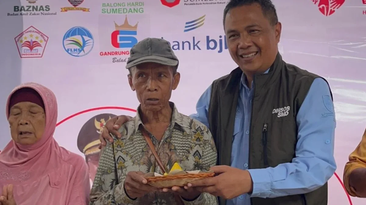 BERIKAN: Kepala Dinas Sosial Kabupaten Sumedang, Dikdik Sadikin, saat memberikan tumpeng ke salah satu lansia