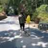 TUNJUKAN: Salah seorang petugas kebersihan Irin (54) saat menunjukan jalan berlubang di Desa Sawahdadap, Senin