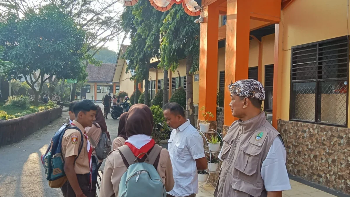 SAMBUT: Kepala Sekolah SMAN Cimanggung Abdur Ropiq saat menyambut siswa di Sekolahnya, baru-baru ini.