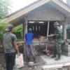 BANGUN: Anggota Babinsa Koramil 1015/Cibugel Serda Zulkifli saat membantu warga membangun pos ronda di Desa Su