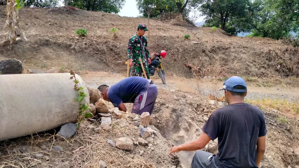 GOTONG ROYONG: Babinsa Desa Lebaksiuh Serda Asep Muhaemin bersama warga saat memperbaiki gorong-gorong, baru-b