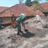 BERSINERGI: Babinsa Desa Cibugeul Serda Tedi Kurnaedi membantu warga membangun rumah, Selasa (10/9).