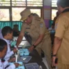 BERIKAN: Pj Bupati Sumedang Yudia Ramli saat memberi makan siang bergizi gratis kepada salah satu siswa di SDN